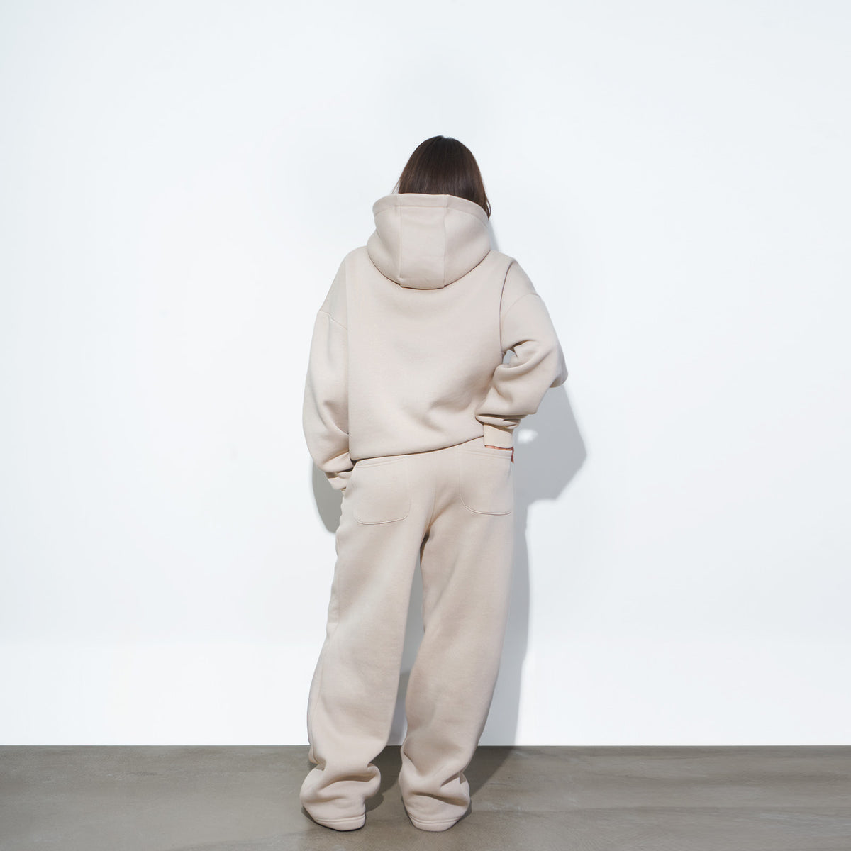 Cozy Tracksuit Cream, Hoodie und Jogginghose in Creme am weiblichen Model, Rückansicht
