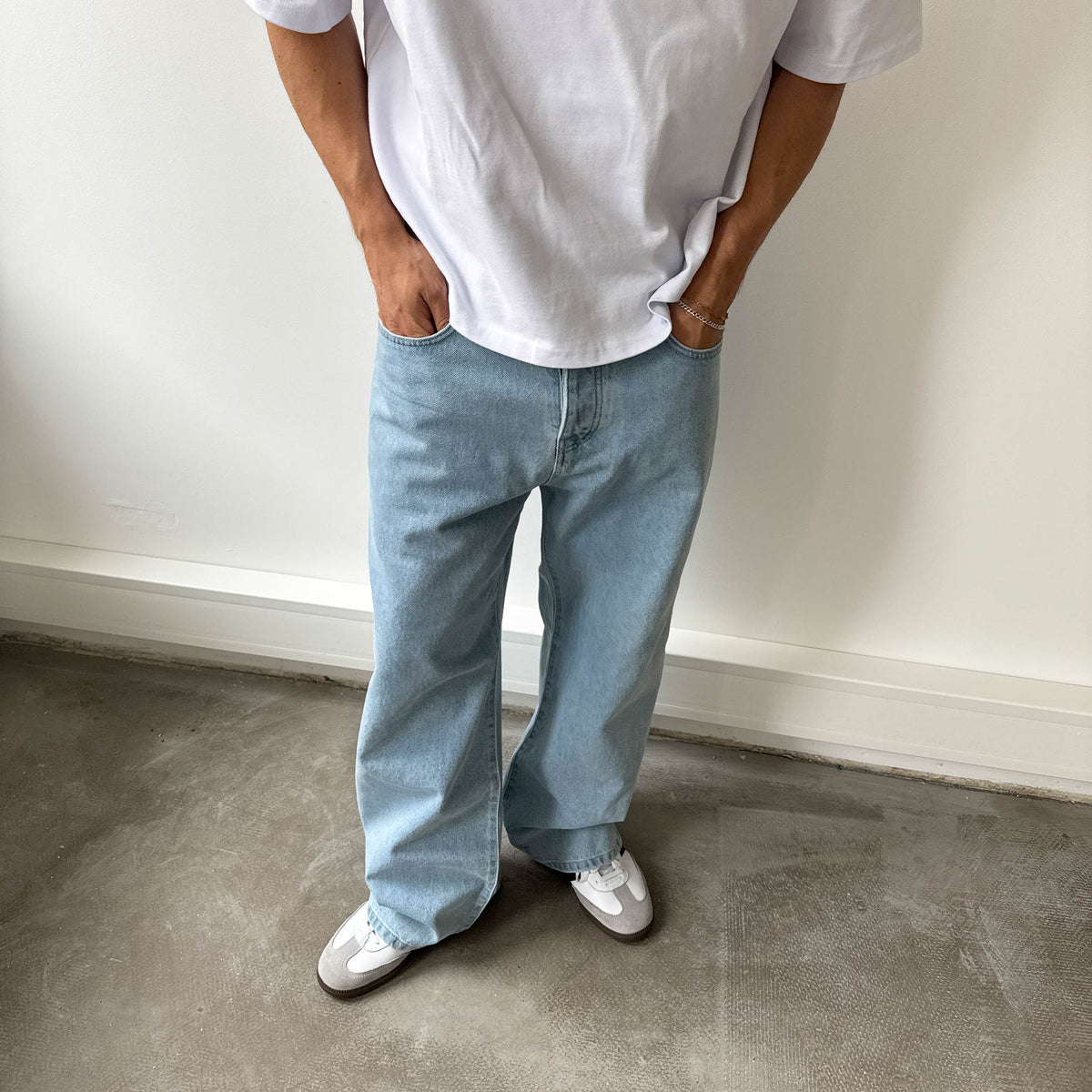 Star Denim Basic Blue am Model, Vorderansicht vor Betonwand