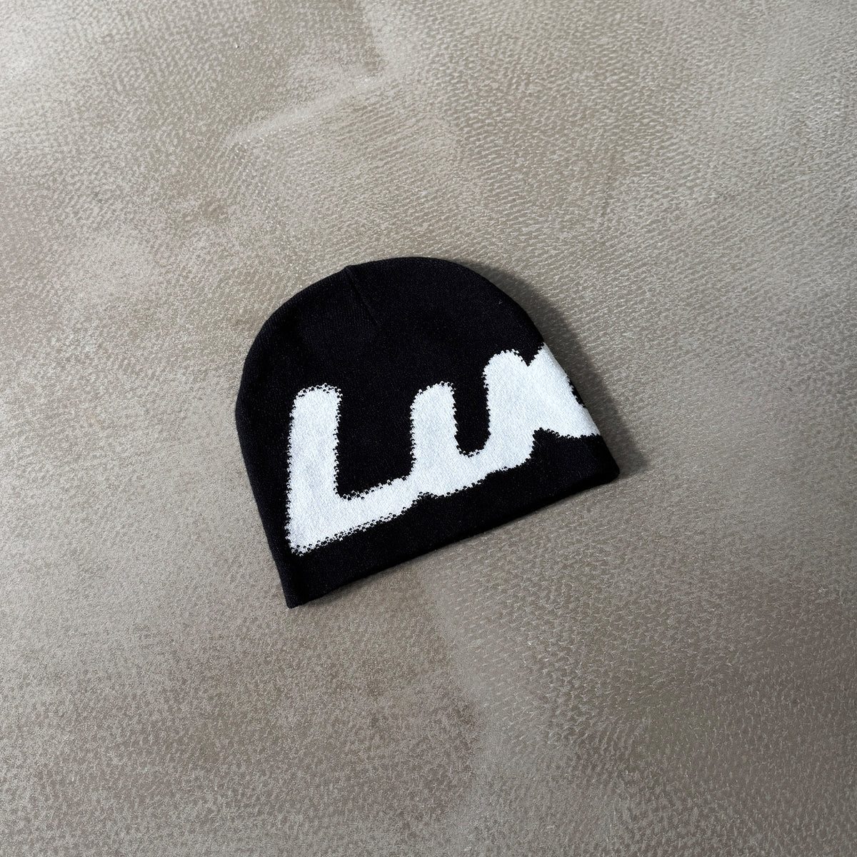 Lucid! Beanie Black Ice liegend auf Beton