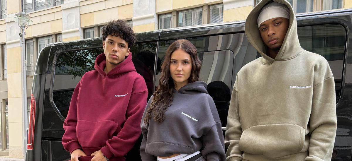 Drei Models im Cozy Tracksuit in Wine Red, Dark Grey und Olive Green an einem Van in Berlin, Querformat