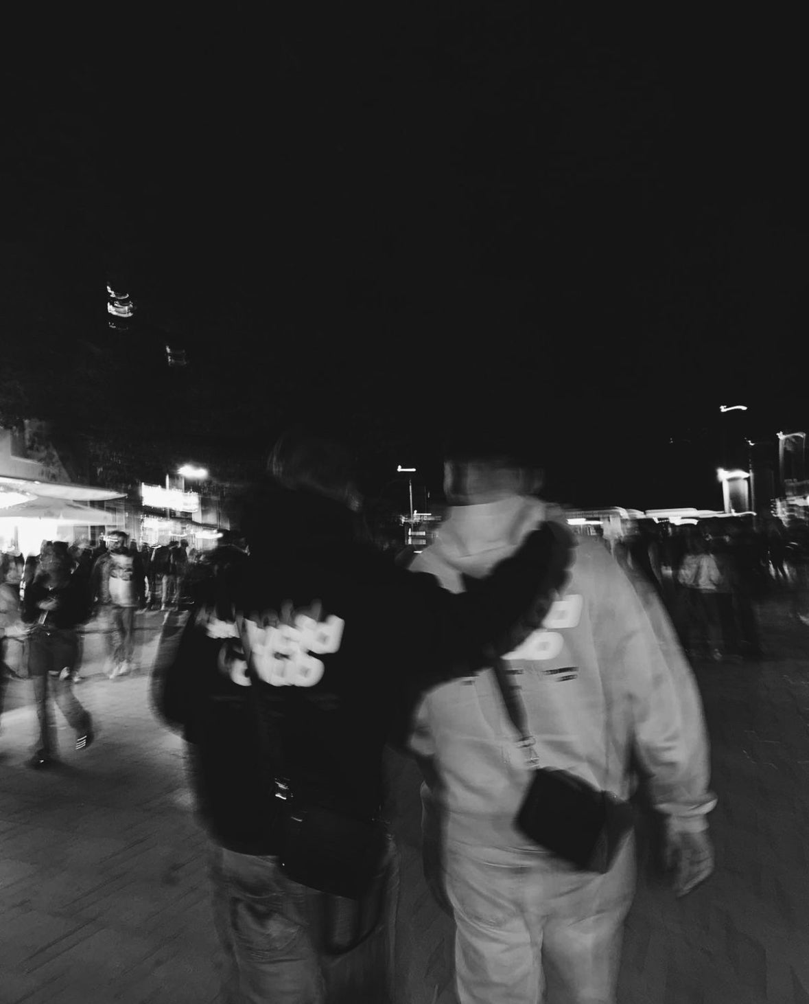 Zwei Freunde in Lucid Club Hoodies nachts auf der Straße, schwarzweiß