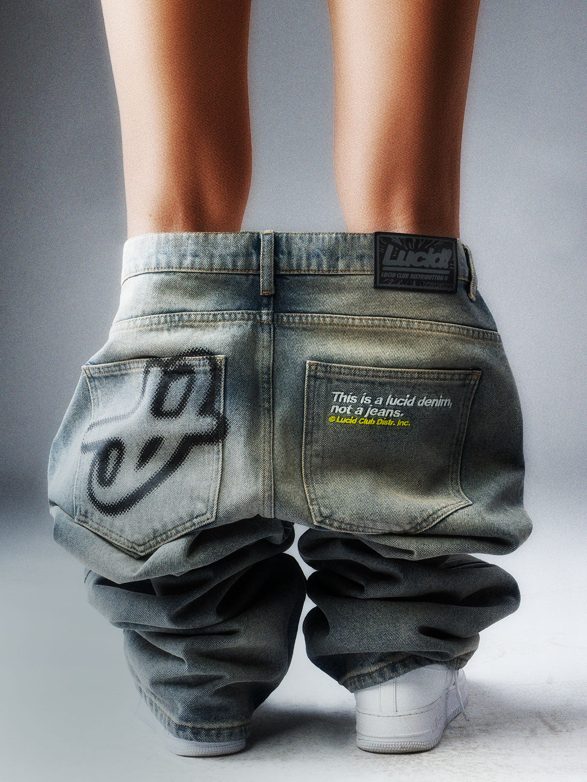 Hell gewaschene Jeans von hinten, Detail von Gesäßtasche und Logo-Patch am Bund