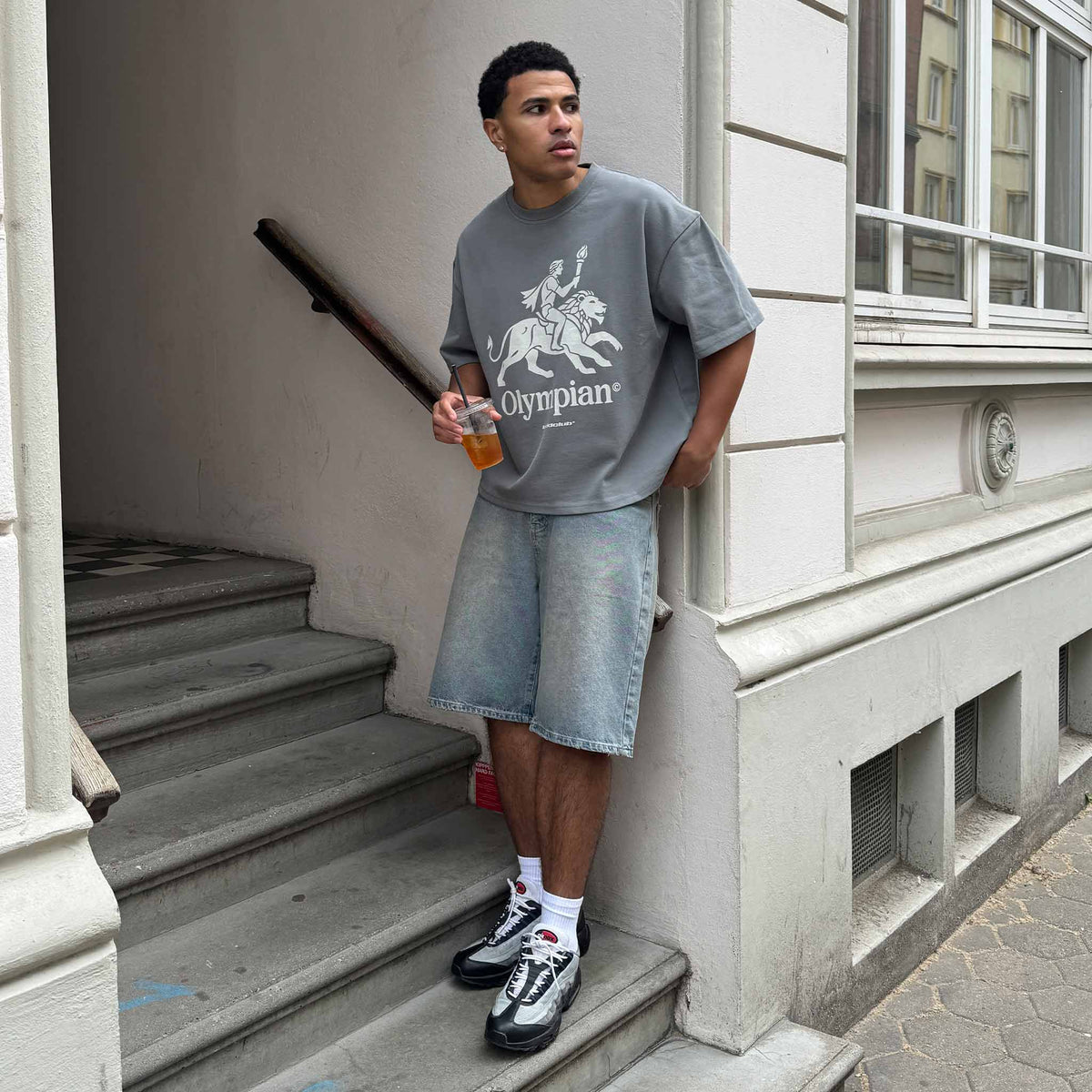 Olympian T-Shirt on model with jorts on the stairs