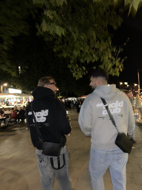 Zwei Freunde in Lucid Club Hoodies nachts unterwegs