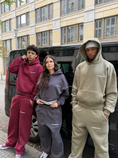 Cozy Tracksuits in Wine Red, Dark Grey und Olive Green, drei Models an einem Van in Berlin