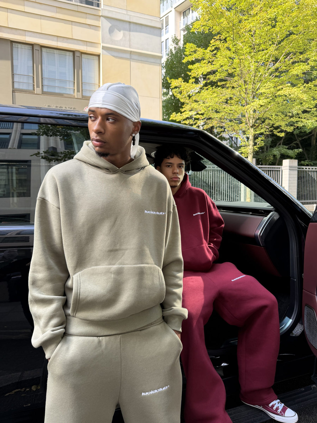 Model im Cozy Tracksuit Olive Green vor einem offenen Auto